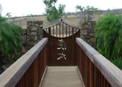 Metal Japanese gate with Japanese characters, walkway and railing.